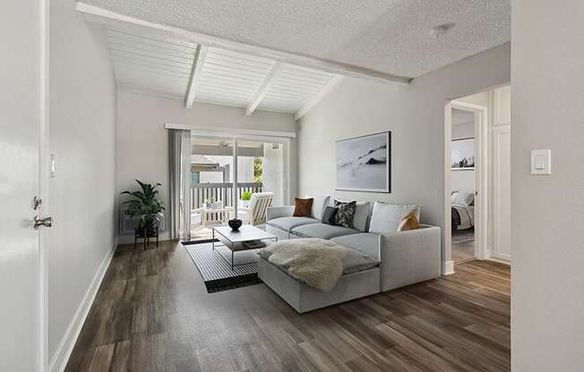 Model Living Room with Wood-Style Flooring and Patio Accessibility at Colonnade at Fletcher Hills Apartments in El Cajon, CA.