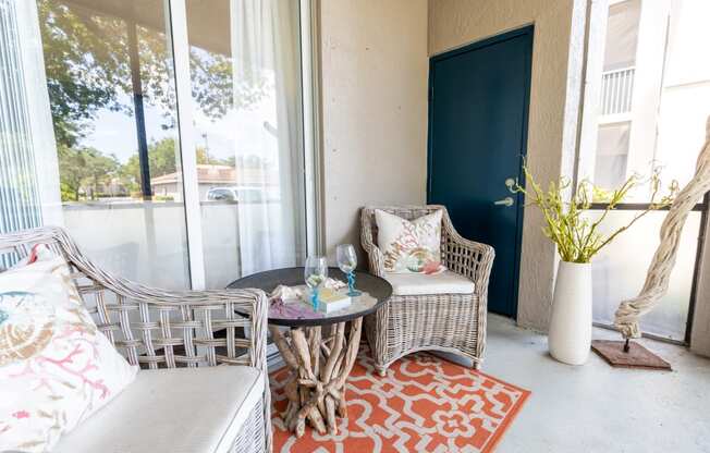 a patio with two chairs and a table at Heritage Bay, Jensen Beach, FL