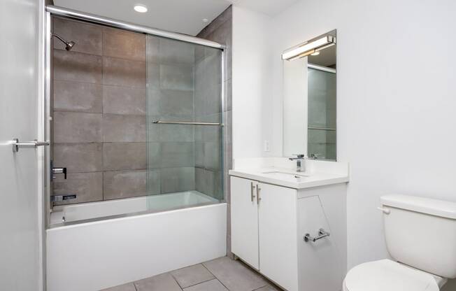 a bathroom with a shower and a sink and a toilet