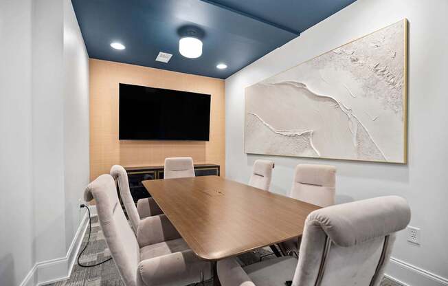 A conference room with a large table and chairs.