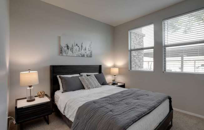 A bedroom with a large bed and a painting on the wall.