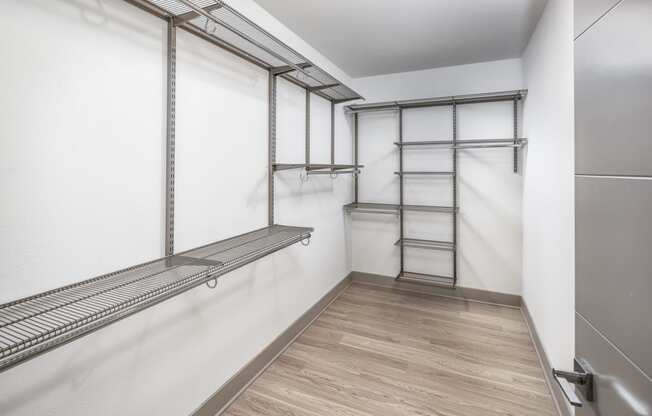 a empty room with a white wall and a mirrored closet with a ladder