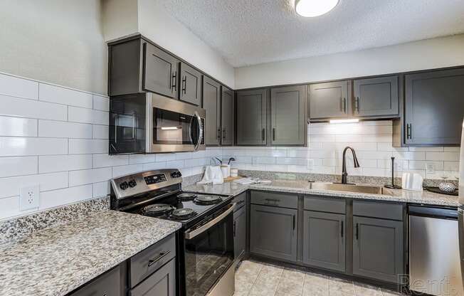 a kitchen with granite counter tops and black appliances