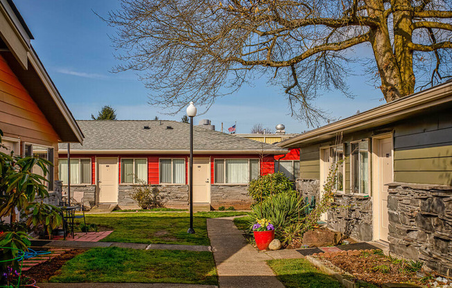 A house with a red awning and a tree in front.