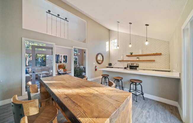 a kitchen with a wooden table and a bar with stools at Bay Village, Vallejo, CA, 94590