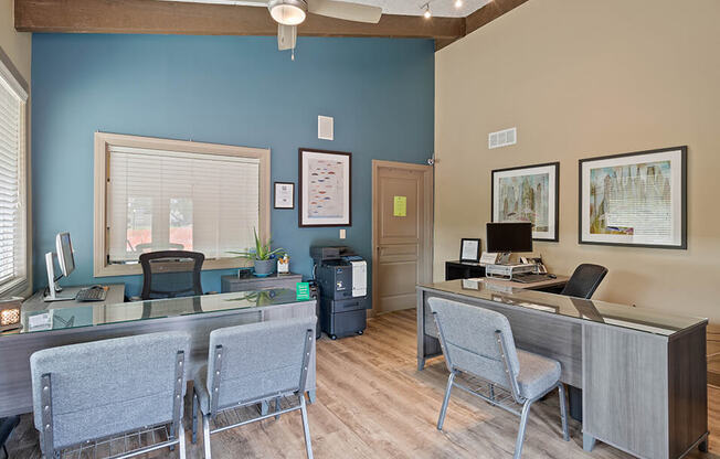 a office with two desks and chairs and a computer