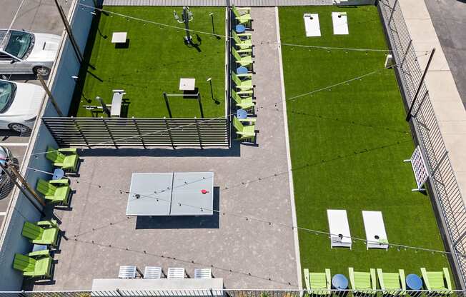 an aerial view of a rooftop with a basketball court and lounge chairs