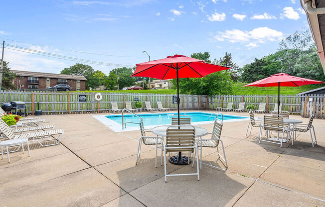 a pool with chairs and umbrellas next to a pool