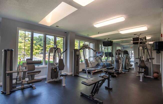 a gym with weights and cardio equipment and windows