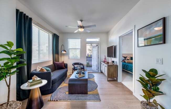 a living room with a couch and a coffee table and a ceiling fan