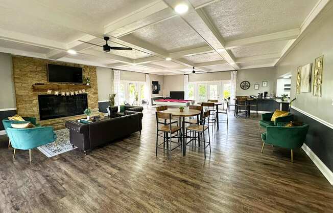 Interior of the clubhouse at Woodbridge Apartments in Bloomington, featuring a fireplace furniture, pool table, and seating areas.