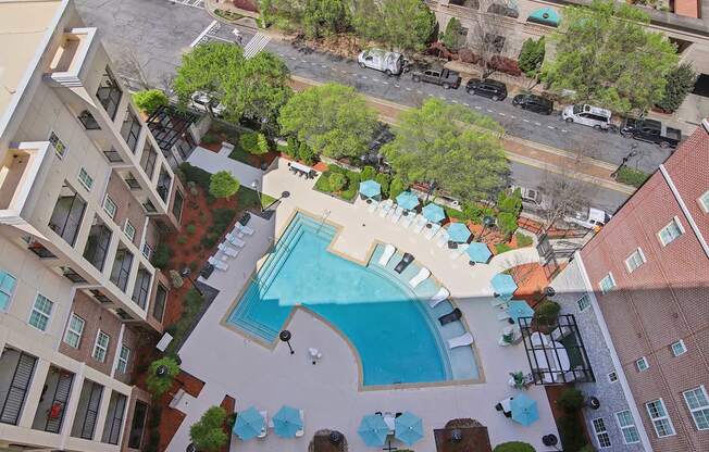 An aerial view of a pool surrounded by buildings.