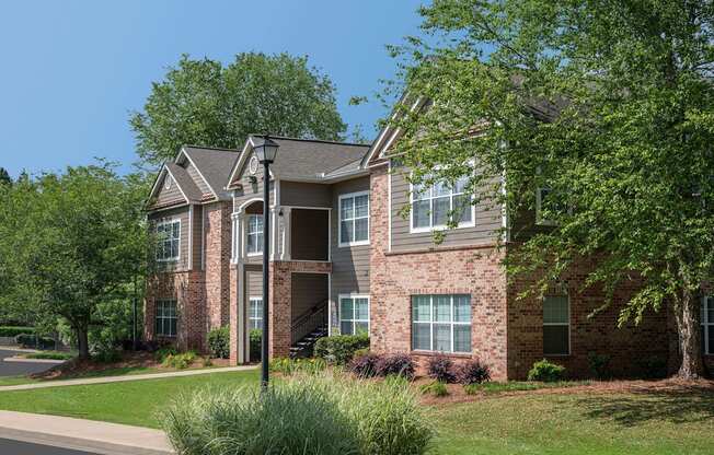 A large brick house with a tree in front.