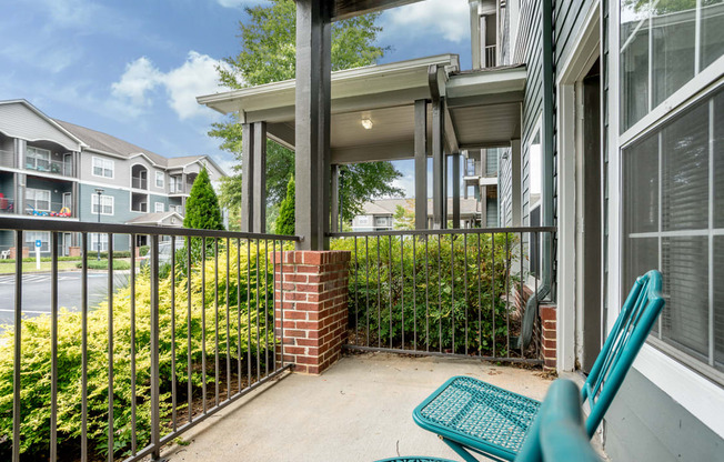 A patio with a blue chair and a brick pillar.