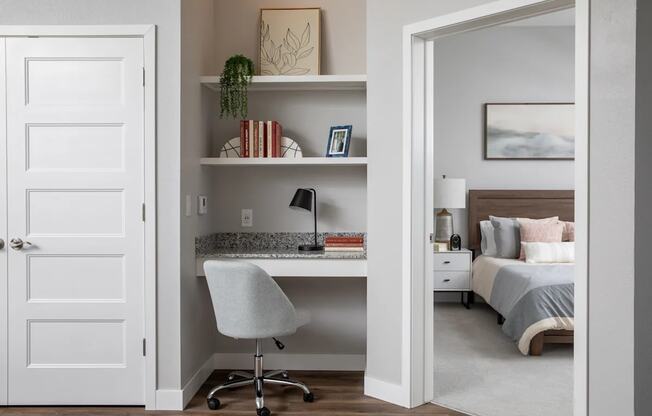 A white chair is in front of a desk with a computer on it.