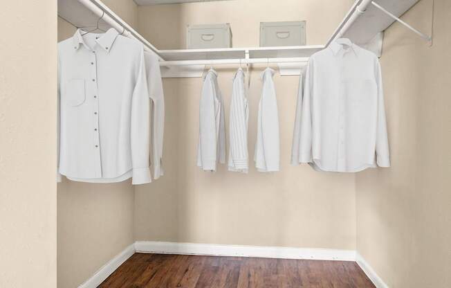 A row of white shirts hanging on a rack.