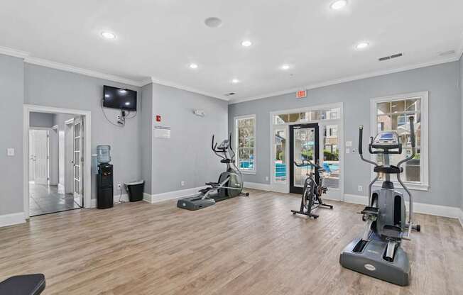 A spacious room with a treadmill, exercise bike, and other workout equipment.