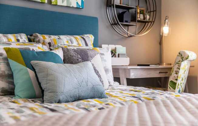 A bed with a blue headboard and a white bedspread with yellow and blue pillows.
