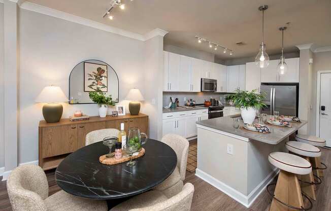 A modern kitchen with a black table and chairs.