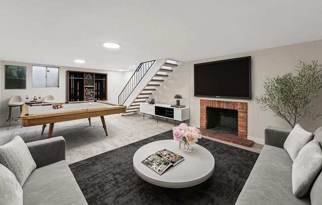 A living room with a grey couch, a coffee table, a fireplace, and a television.