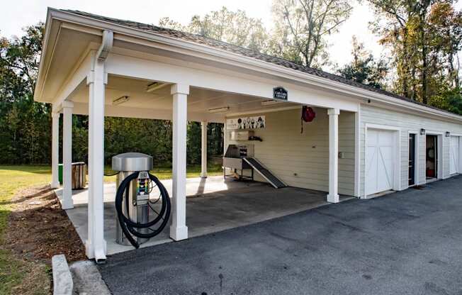the front of a garage with a gas pump in the driveway