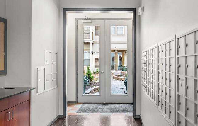 A modern interior with a view of a courtyard through a glass door.