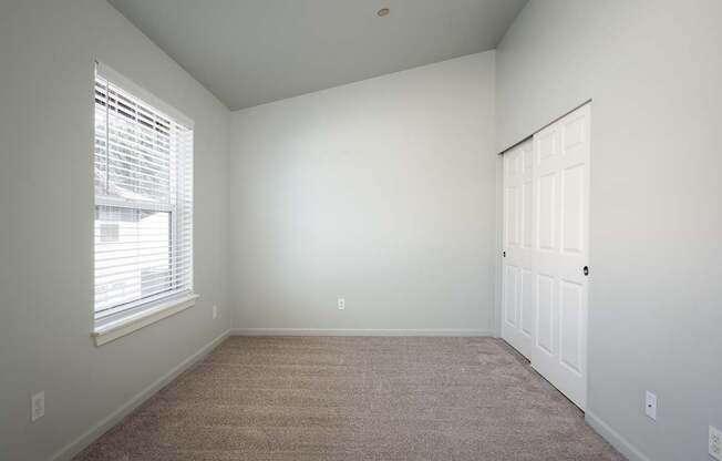 A room with a carpeted floor and a white door.