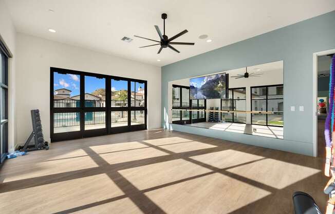 A room with a ceiling fan and a large window overlooking a balcony at The Villas at Anacapa Canyon, Camarillo, 93012