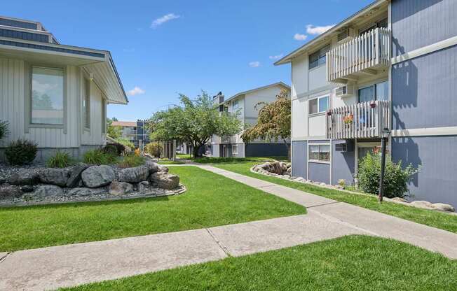 A sunny day in a residential area with apartment buildings and a well-kept lawn.