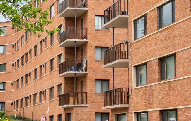 a large brick building with many balconies and a street in front