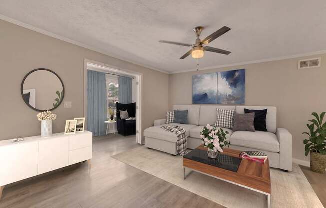 A modern living room with a white sofa, a coffee table, and a ceiling fan.