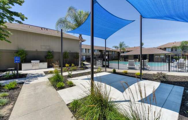 Exterior Courtyard with sunshade over concrete pad. Pathway leading to outdoor BBQ area.