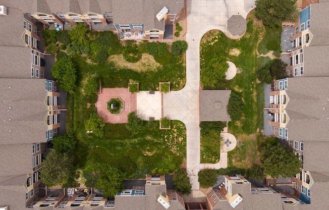 an aerial view of a building shaped like a face with grass and trees