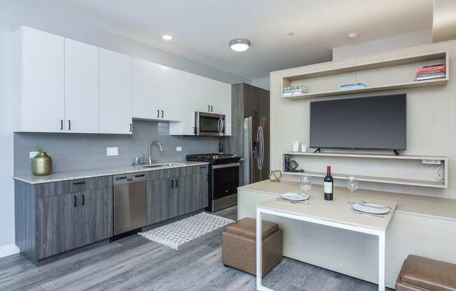 a kitchen and living room with a table and a television