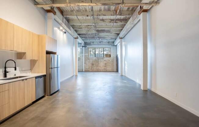 a kitchen with a sink and a refrigerator in a room with white walls