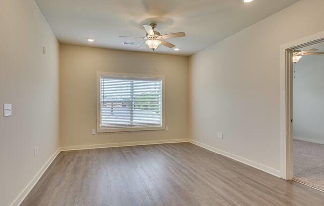 an empty living room with a ceiling fan at The Augustan, Augusta, Georgia