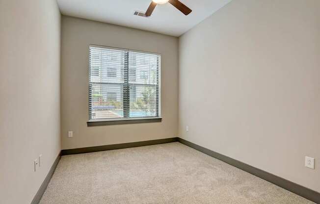 Pet-Friendly Apartments in Nashville, TN- Octave Apartments-  Bedroom with plush carpet and a ceiling fan