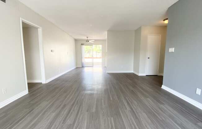 the living room and dining room of an apartment with wood flooring