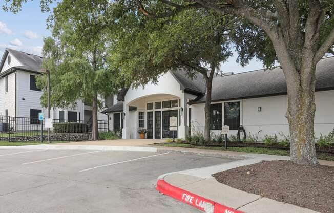 the exterior of a building with a parking lot and trees