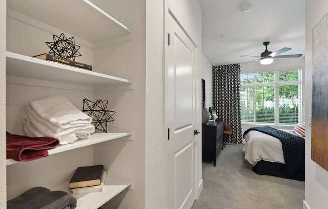 A white shelf with towels and a book on it.