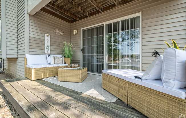 a covered porch with two beds and a window