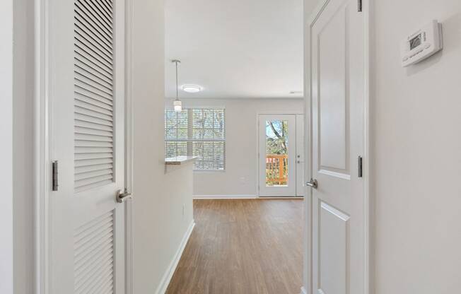 a hallway with white doors and a door to a living room with a door open