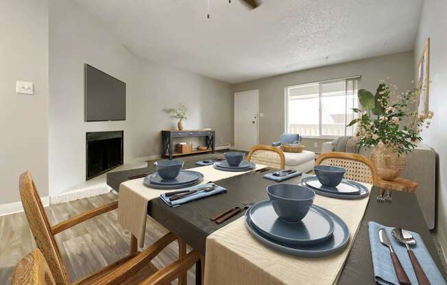 A dining table set with blue plates and cutlery.