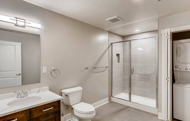 a bathroom with a shower toilet and sink and a mirror