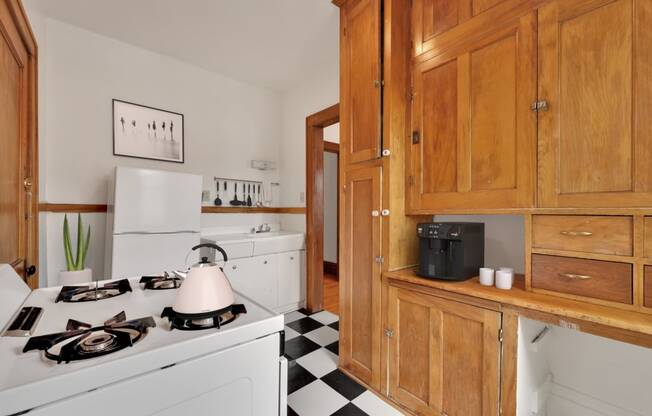 a kitchen with wooden cabinets and a black and white checkered floor