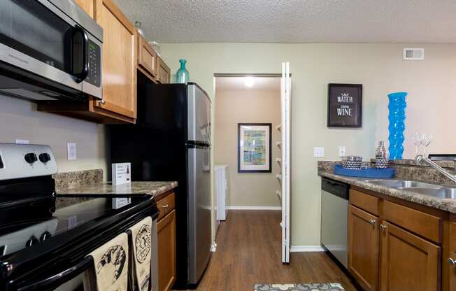 Apartment kitchen with stove, microwave, and refrigerator in Blue Ash, OH.
