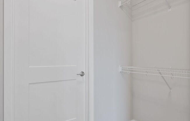A white door is on the left and a white shelf is on the right.