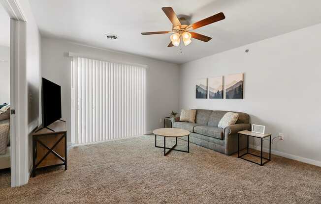 a living room with a couch and a ceiling fan