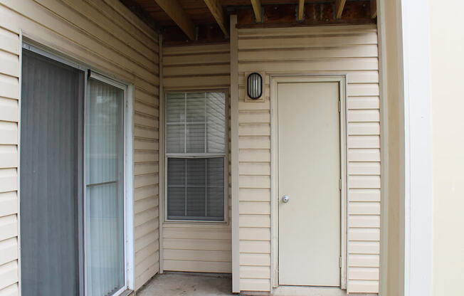 a front porch with a white door and a window