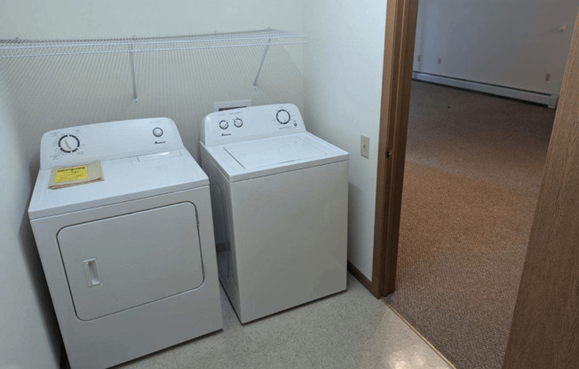 three washing machines in a room next to a door